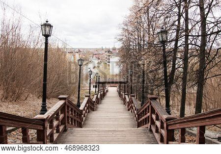 Wooden High Staircase For Descent From The Mountain To The City. Lanterns, Massive Railings. Old Tre
