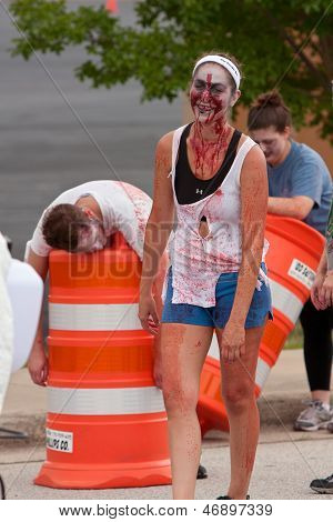 Weibliche Zombie mit blutigen Gesicht Stiele Läufer In 5K Race
