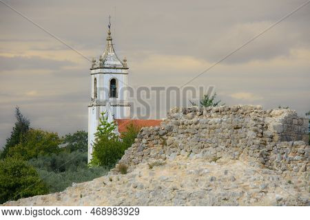 Ruins Of The Old Roman City Of Conimbriga In Portugal With A Medieval Church In The Background