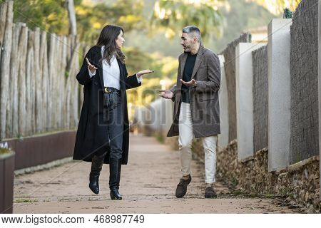 A Couple Walking On A Path And Arguing