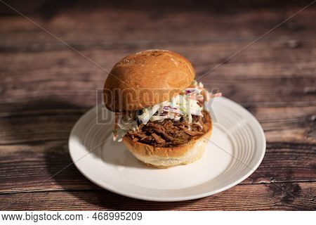 Pulled Pork Sandwish With Coleslaw On A Plate.