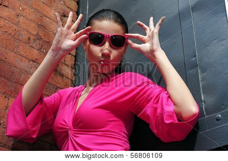 Young brunette model posing in pink dress