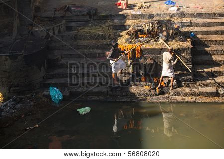 KATHMANDU, NEPAL - DEC 3: Unidentified local people during the cremation ceremony along the holy Bagmati River in Bhasmeshvar Ghat at Pashupatinath temple, Dec 3, 2013 in Kathmandu, Nepal.