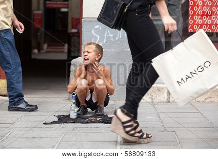 SARAJEVO, BOSNIA AND HERZEGOVINA - AUG 11: Sevdalija Osmanovic, 10 years old, sings on street to bypassers on August 11, 2012 in Sarajevo, B&H. He sings in order to provide money for his family.