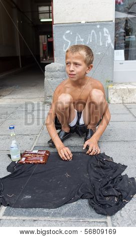 SARAJEVO, BOSNIA AND HERZEGOVINA - AUG 11: Sevdalija Osmanovic, 10 years old, sings on street to bypassers on August 11, 2012 in Sarajevo, B&H. He sings in order to provide money for his family.