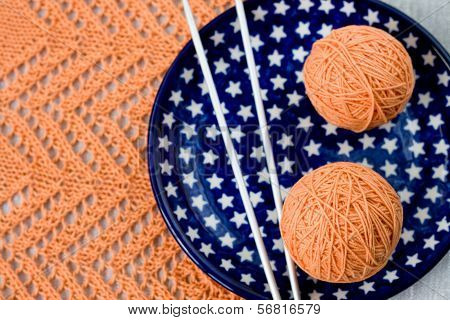 Orange balls, knitted pattern and knitting nedles