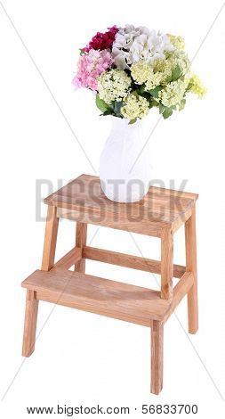 Vase with flowers on small wooden ladder, isolated on white