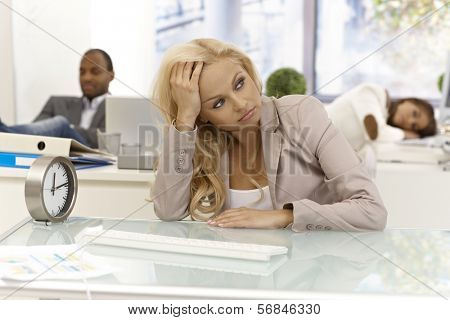 Office workers sitting bored at desk in office, some of them are sleeping.