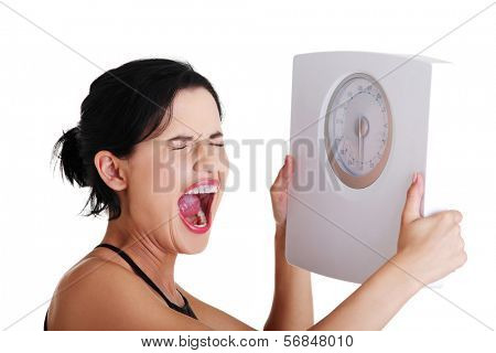 Frustrated woman with scale, isolated on white