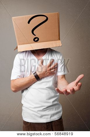 Young man standing and gesturing with a cardboard box on his head with question mark