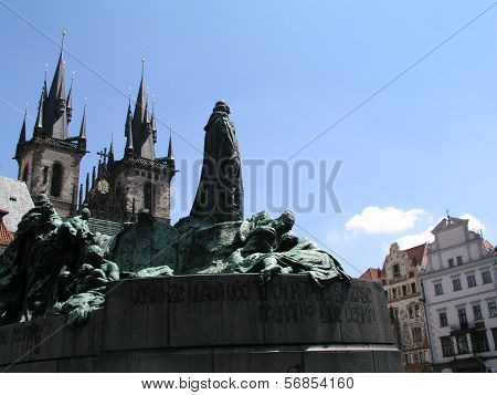 View of old town square in Prague, including the Jan Hus monument and the towers of the Tyn church