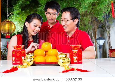 Friends family celebrate Chinese new year traditional with gift, wearing red shirts