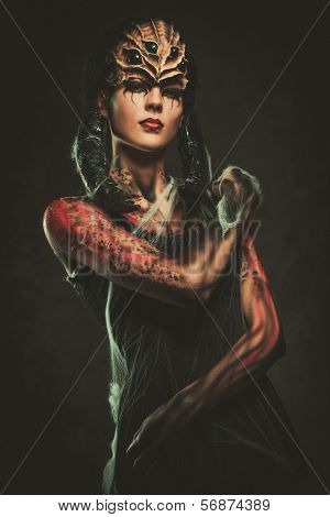 Young woman with spider body art and mask