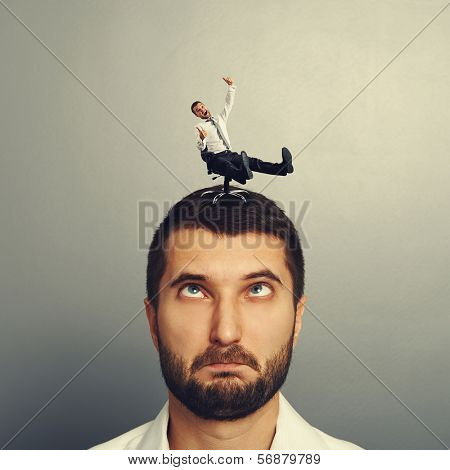 portrait of foolish man with small laughing man on the head