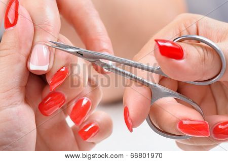 beauty salon, manicure applying, cutting the cuticle with scissors