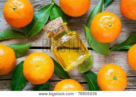 Ripe Tangerines With Leaves And Bottle Of Essential Citrus Oil On A Wooden Table. Top View.