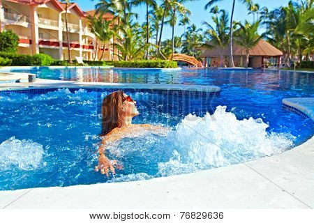Woman relaxing in jacuzzi. Vacation at caribbean resort.