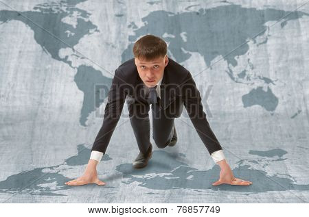 Young businessman standing in start pose ready to run.  WTO concept
