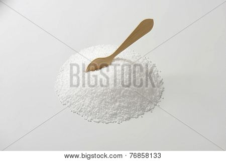 heap of salt with immersed wooden spoon