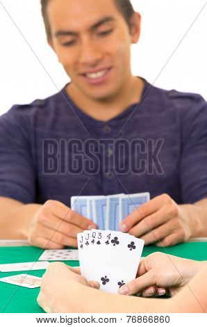 young man playing cards cuarenta traditional Ecuadorian game