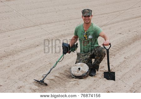 Kiev,Ukraine.June 3.Military archeology. Man with metal detector and German WWII anti tank landmine.At June 3,2012 in Kiev, Ukraine 