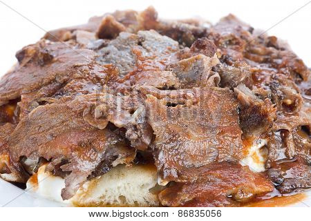 Close up of traditional Turkish food iskender kebab, doner at the top of yoghurt and tomato sauce.  