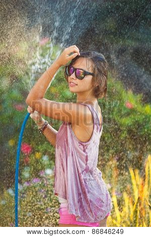Photo of young woman enjoying shower outdoors