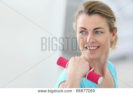 Portrait of mature fitness woman lifting dumbbells