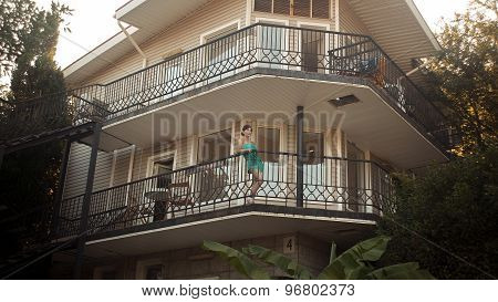 Beautiful young woman standing on terrace 2