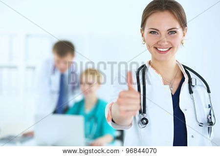Female doctor shows a sign okay standing in hospital