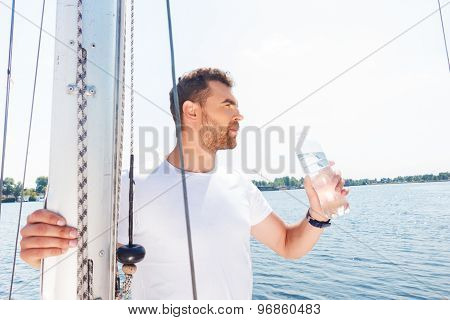 Nice man drinking water on yacht
