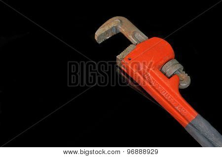 Large Adjustable Wrench With Red Handle Isolated On Black