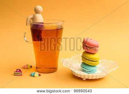 Colourful macaroons and ginger tea on a backround