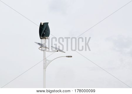 Wind power turbine and solar panel in a power generation plant. Cloudy sky and empty copy space for Editor's content