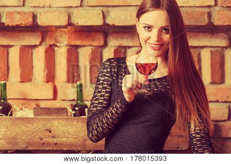 Woman Tasting Wine In Rural Cottage Interior