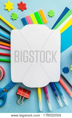 Vintage frame with stationery on the blue background. Multicolor pencils and crayons apple. Place for your text.