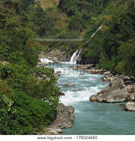 Suspension bridge over the turquoise Marsyangdi river. Annapurna Conservation Area Nepal.