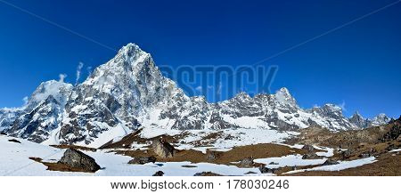 Majestic Himalayan mountains Nepal. Panoramic view of the mountain ridge covered with snow on the background of deep blue sky.