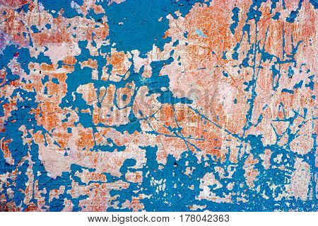 Abandoned wall with blue paint on. Grungy background with weathered plaster and destroied paint.