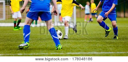 Football Player Running with the Ball on the Pitch. Footballers Kicking Football Match on the Pitch. Young Teen Soccer Game. Youth Sport Horizontal Background