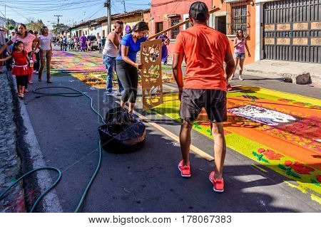 Antigua, Guatemala - March 19 2017: Locals make Lent carpets of dyed sawdust using stencils in path of religious procession in colonial town with most famous Holy Week celebrations in Latin America.