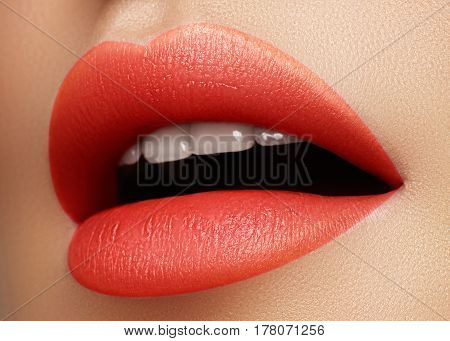 Cosmetics makeup and trends. Bright lip gloss and lipstick on lips. Closeup of beautiful female mouth with red and pink lip makeup. Beautiful part of female face. Perfect clean skin