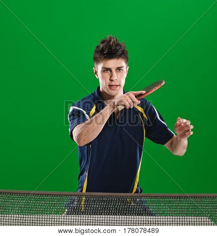 Young male athlete playing table tennis on green chromakey background