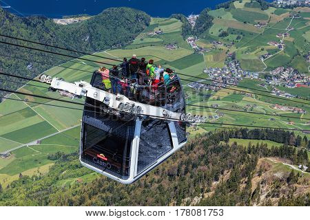 Mt. Stanserhorn, Switzerland - 7 May, 2016: people in a gondola of the Stanserhorn Cabrio cable car. The Stanserhorn Cabrio is the the world's first double deck open top cable car, it carries 60 passengers per cabin with room for 30 on the open deck.