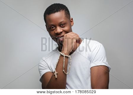Portrait of smiling young african american man on grey background with freespace. Happy emotions, joy, gladness, good luck.