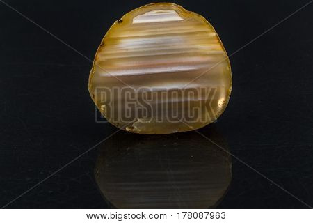 An attractive amazing mineral Agate cut
 on a black glossy surface, from a personal collection of semi-precious stones and minerals