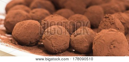 Truffles of dark chocolate close-up on a plate