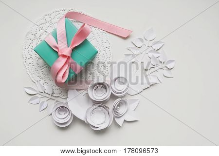 A Gift On A White Napkin And White Paper Flower