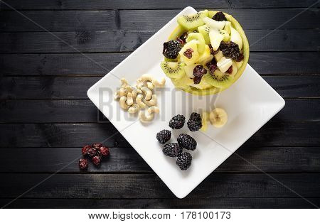 Variety of fruits and nuts on a black table top view. Concept of health and nutrition