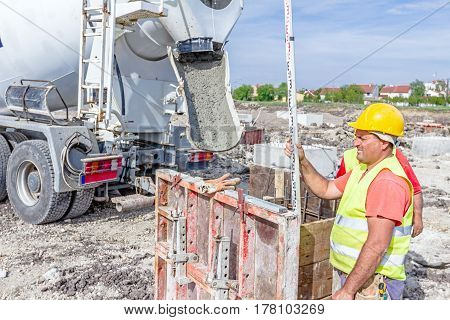 Zrenjanin Vojvodina Serbia - April 30 2015: Construction worker is holding leveling rod to help surveyor geodesist to measure position depth.